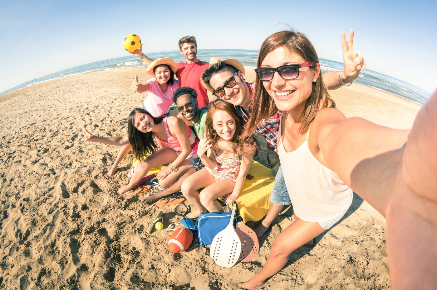 Group of friends taking a selfie together on a sunny beach